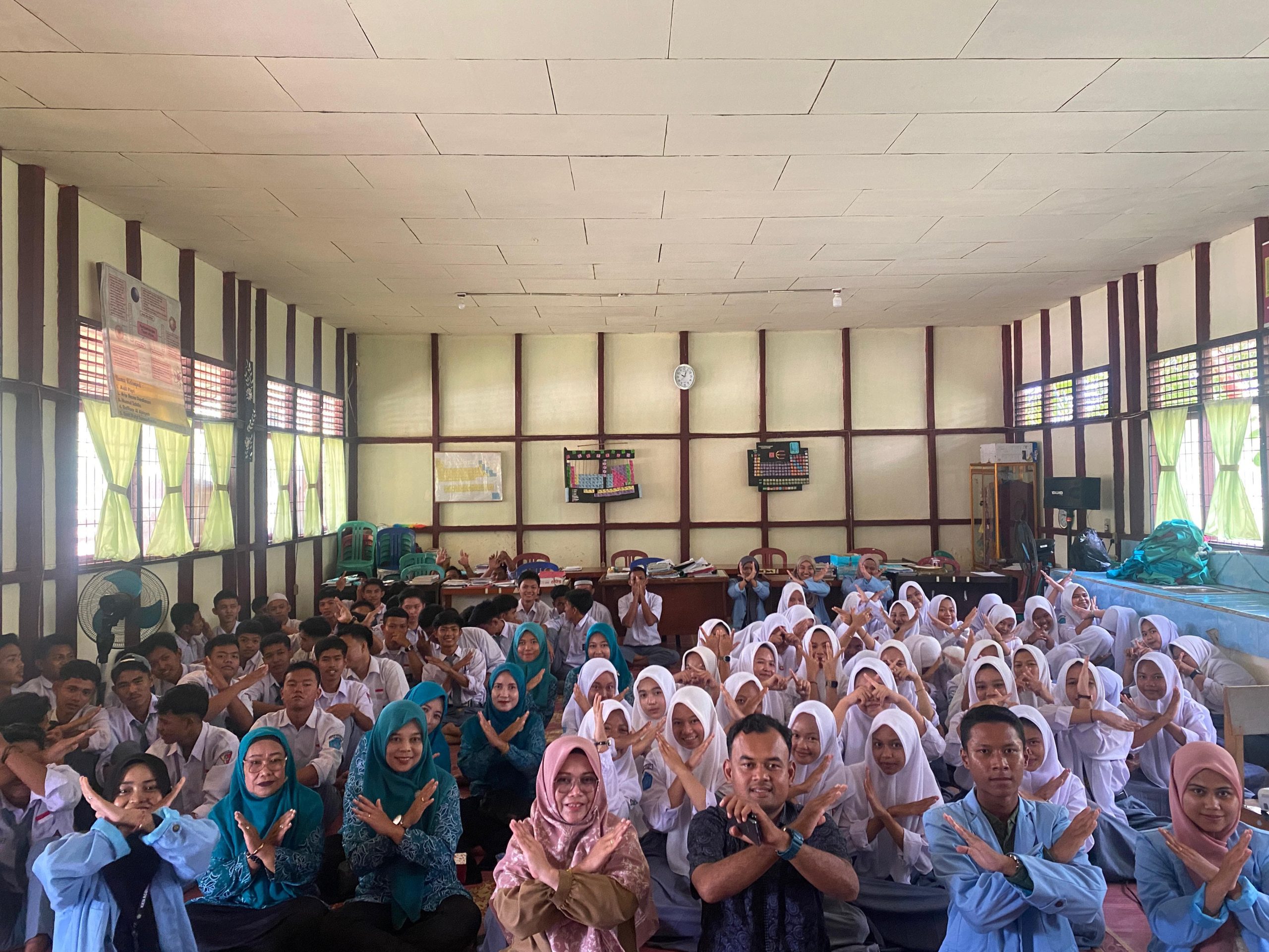 Group photo of UNRI Kukerta students with participants and speakers after the socialization of online gambling, online loans and juvenile delinquency at SMA Negeri 1 Enok, Tuesday (07/30/2024). (doc. Kukerta UNRI)